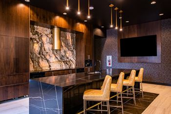 State of the art kitchen with dark marble and waterfall countertops